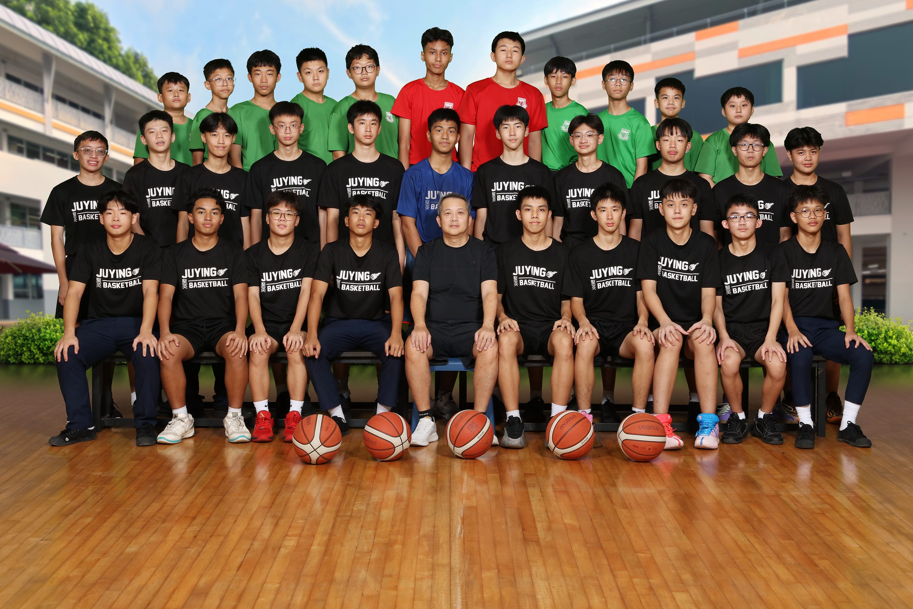 Juying Secondary School Basketball team 2024 group photo with students and coaches posing indoors.